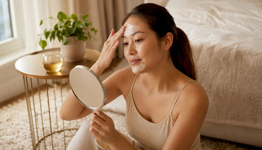 Woman applying facial mask in bathroom